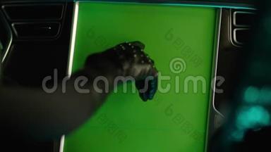 穿着黑色衣服开车的女人推着绿色屏幕控制面板